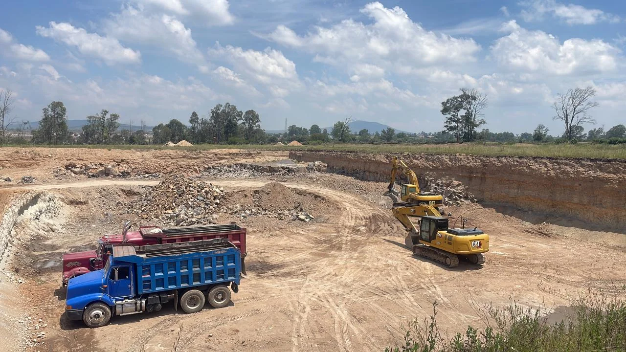 Camión de volteo y excavadora en obra